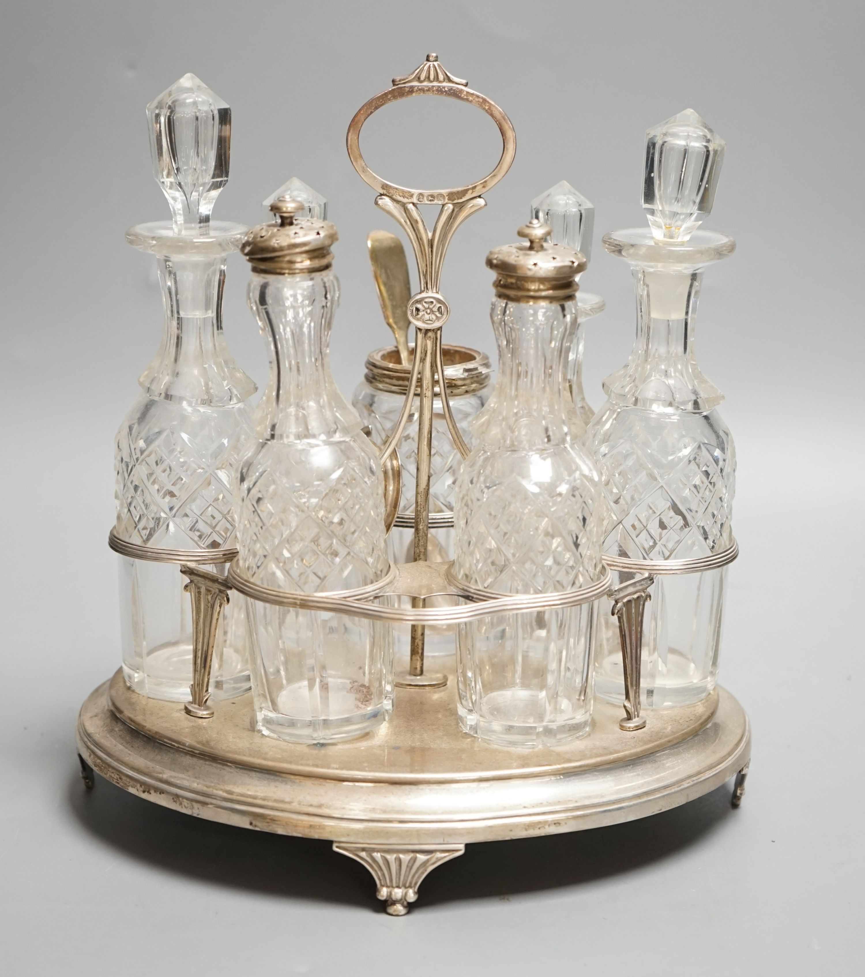 A George III silver oval cruet stand, Henry Nutting, London, 1805, height 25cm, 17.5oz, with six later associated glass bottles.